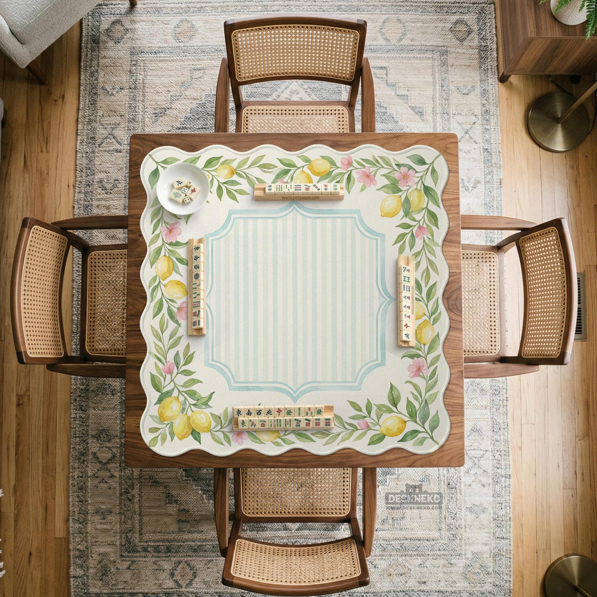 Square yellow mahjong mat with a citrus garden border, green vines, pink blossoms, aqua accents, and a plain center play area.