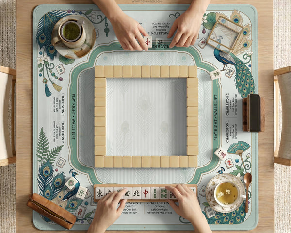 Teal square mahjong mat with peacock feathers, soft floral pattern, tassel details, and printed rule guide text in the center.