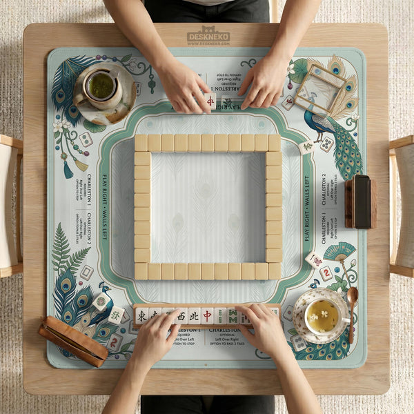 Teal square mahjong mat with peacock feathers, soft floral pattern, tassel details, and printed rule guide text in the center.