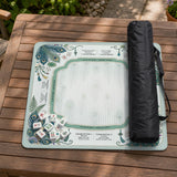 Teal square mahjong mat with peacock feathers, soft floral pattern, tassel details, and printed rule guide text in the center.