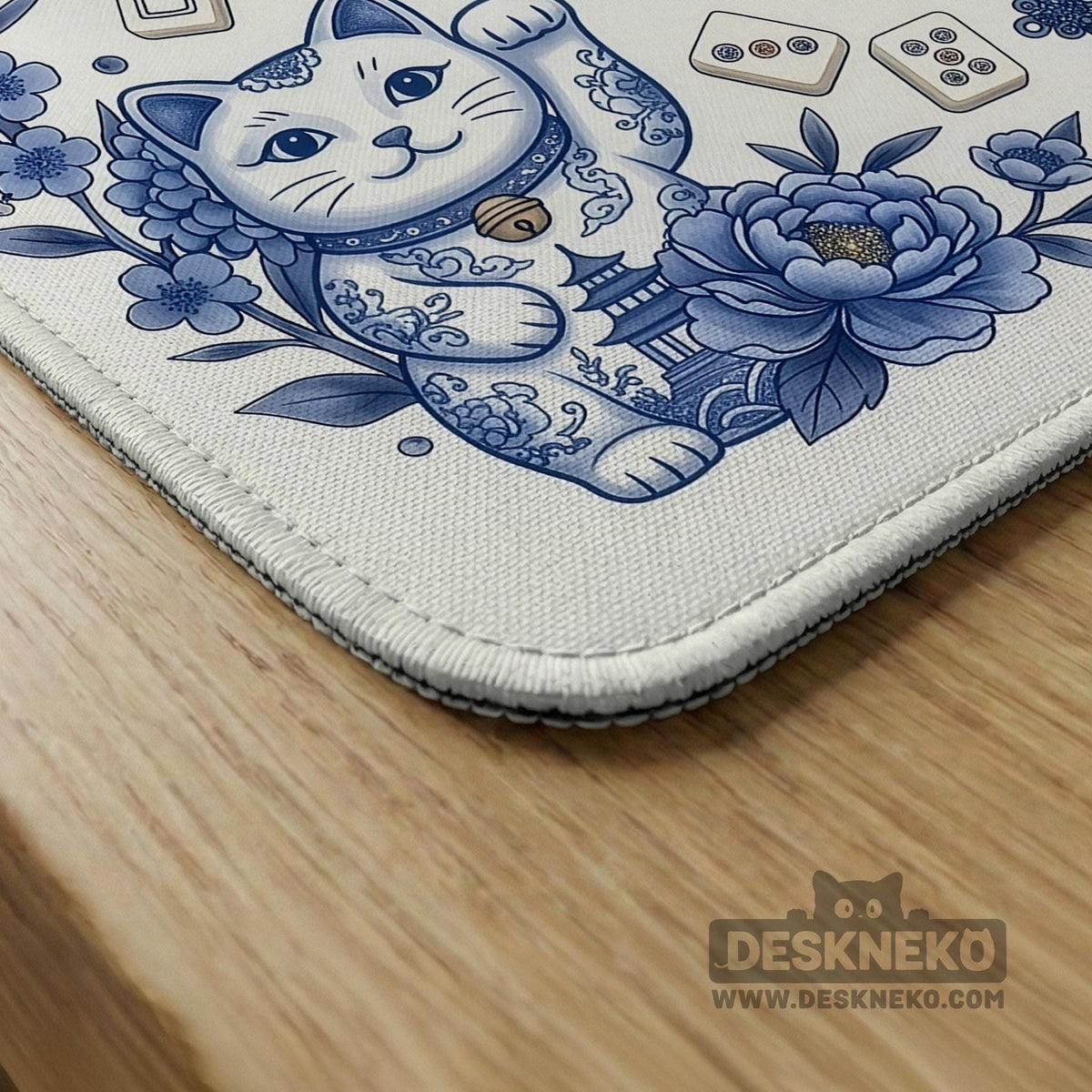 Blue and white square mahjong mat with lucky cat artwork, floral chinoiserie pattern, tile icons, and a rule guide layout.