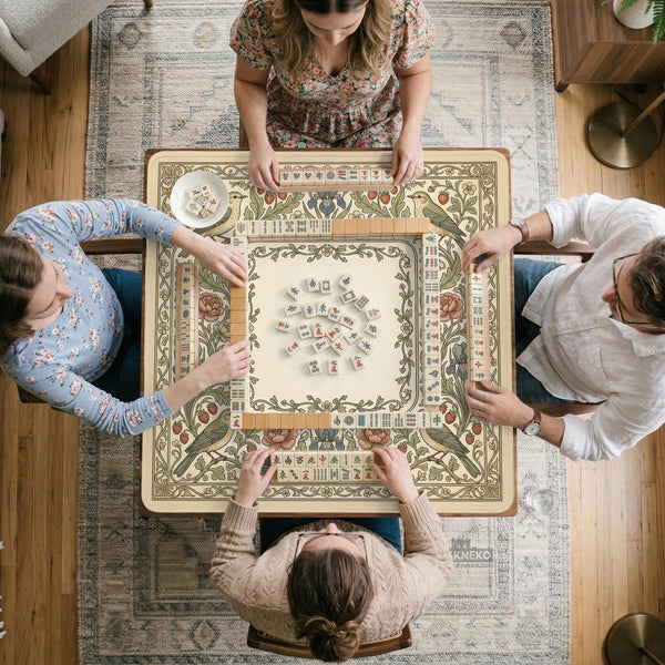 Square mahjong table mat with vintage bird artwork, floral border detail, and sage green, cream, muted blue, and terracotta tones.