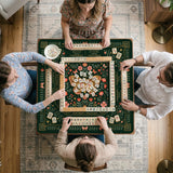 Dark botanical mahjong table mat with a floral border, large moth and butterfly design in the center, gold corner frame, and printed rules layout around the edge.