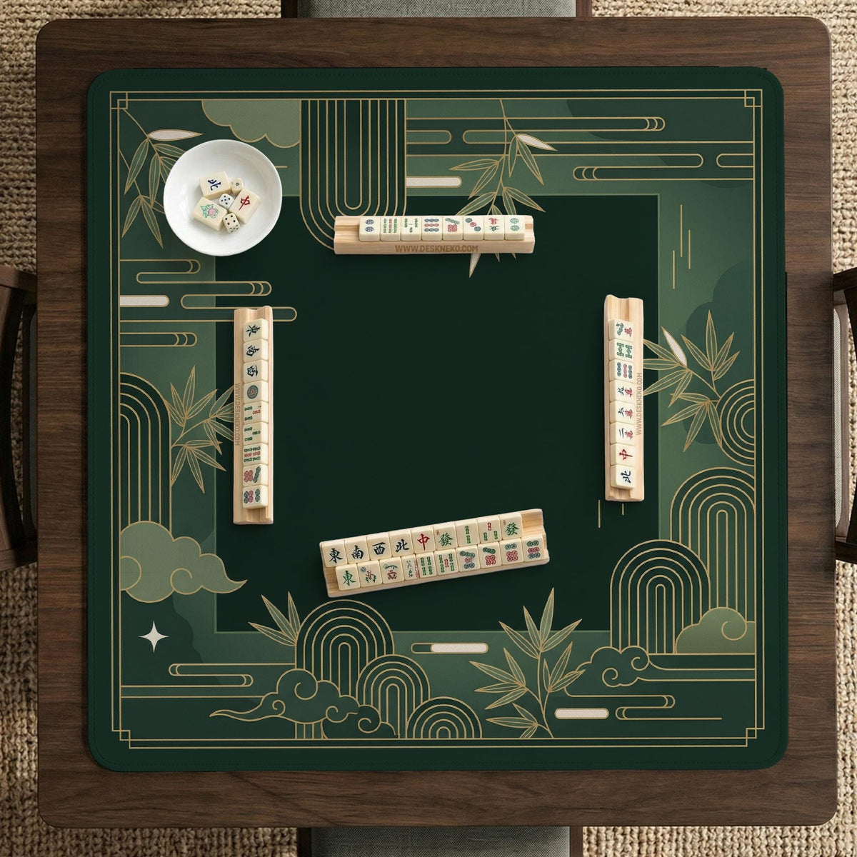 Square emerald green mahjong mat with bamboo line art, gold geometric cloud shapes, and a plain center playing area.