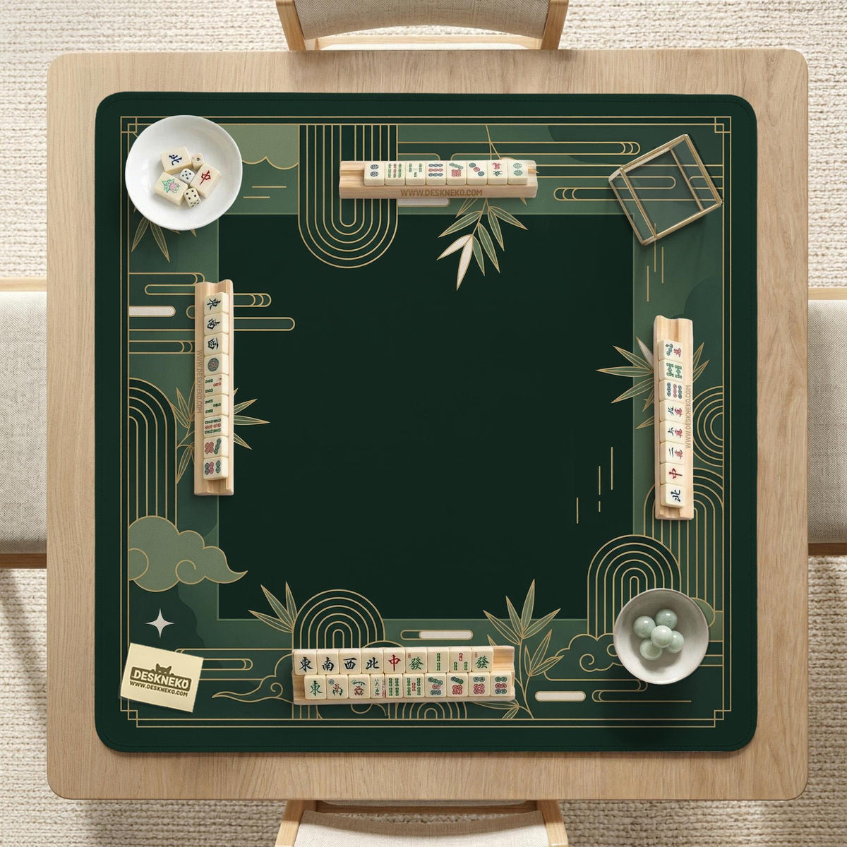 Square emerald green mahjong mat with bamboo line art, gold geometric cloud shapes, and a plain center playing area.