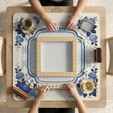 Blue and white mahjong table mat with a floral border, small birds, pagoda details, striped center, and printed rules around the edge.