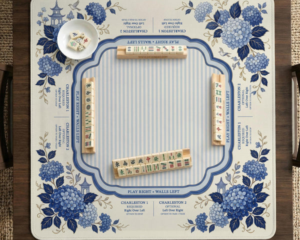Blue and white mahjong table mat with a floral border, small birds, pagoda details, striped center, and printed rules around the edge.
