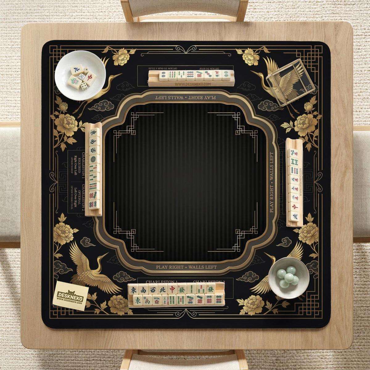 Black and gold square mahjong mat with an art deco crane and floral border, rule reminders around the edges, and a blank center area.
