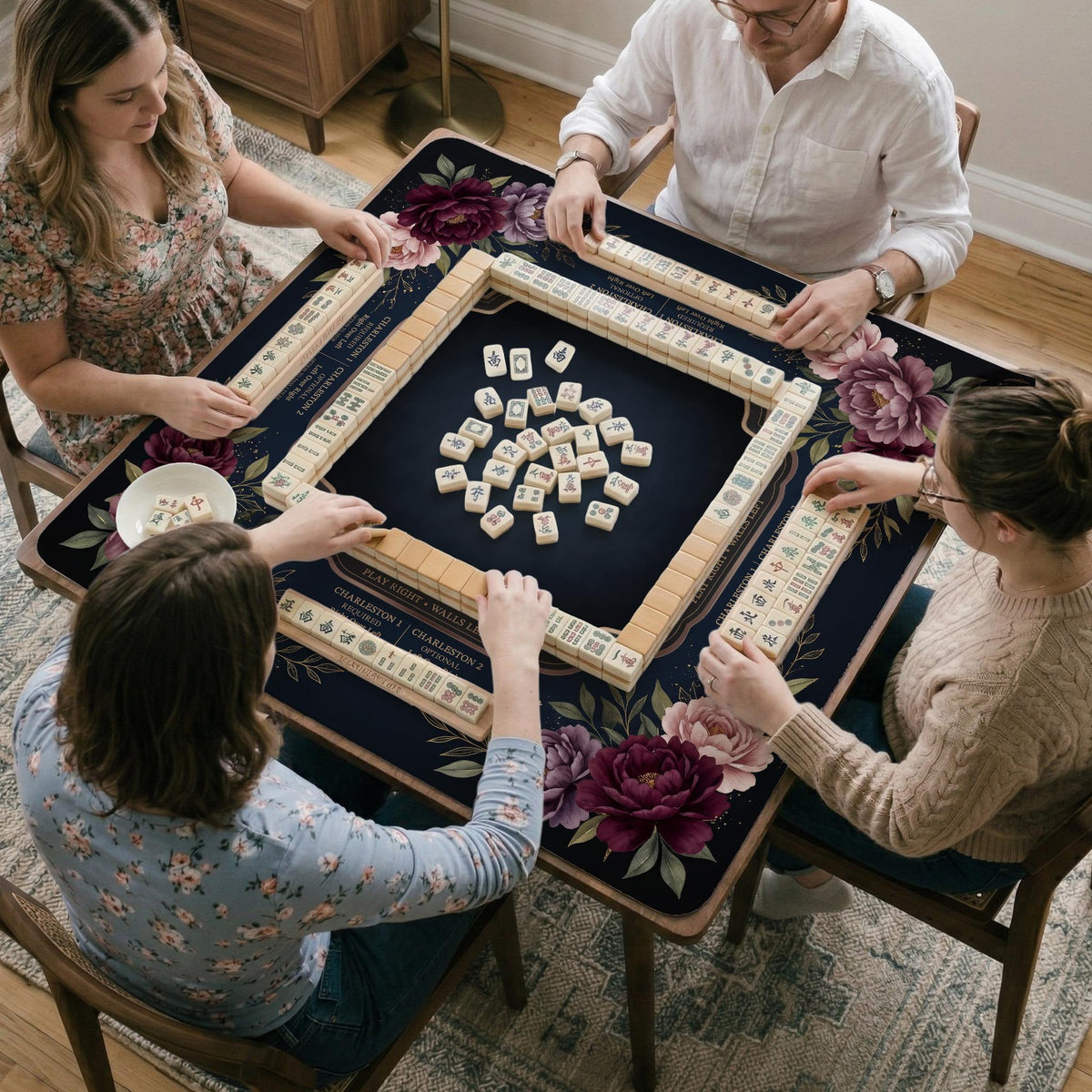 Burgundy mahjong mat with a floral border, gold botanical details, and printed American Mahjong rules on a dark background.