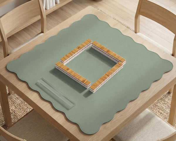A square sage green mahjong mat with scalloped edges on a plain background.