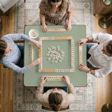 A square sage green mahjong mat with scalloped edges on a plain background.