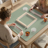 A square sage green mahjong mat with scalloped edges on a plain background.