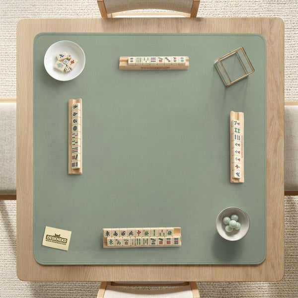 A square sage green mahjong mat with scalloped edges on a plain background.