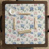 Pink floral mahjong table mat with peonies, blue hydrangeas, sage green leaves, and an ivory background.