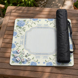 A square mahjong mat with blue hydrangea flowers, green vines, a cream background, a striped center, and printed rules around the border.