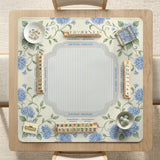 A square mahjong mat with blue hydrangea flowers, green vines, a cream background, a striped center, and printed rules around the border.