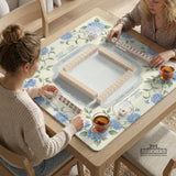 A square mahjong mat with blue hydrangea flowers, green vines, a cream background, a striped center, and printed rules around the border.