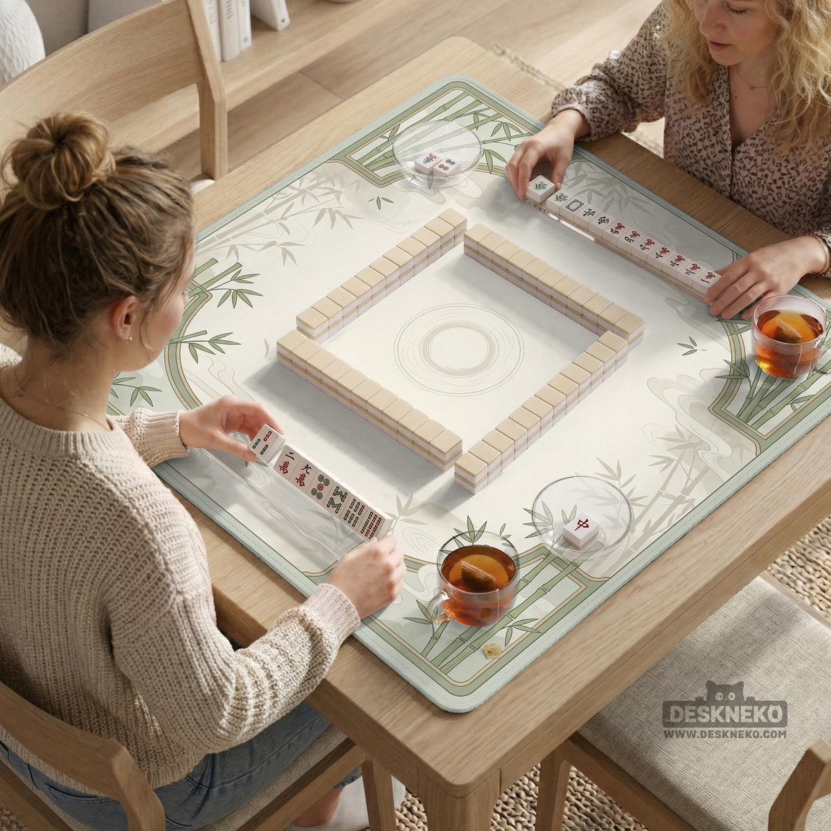 Square mahjong table mat with a pale cream center and green bamboo chinoiserie corners and border.