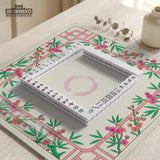 Pink cherry blossom floral mahjong table mat with a cream center and bamboo-style border design.