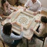 Sage and cream mahjong mat with a koi fish pond pattern, lotus blooms, water ripples, and printed instructions around the border. One version has a scalloped edge.