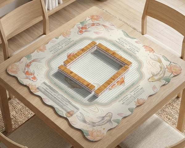Sage and cream mahjong mat with a koi fish pond pattern, lotus blooms, water ripples, and printed instructions around the border. One version has a scalloped edge.