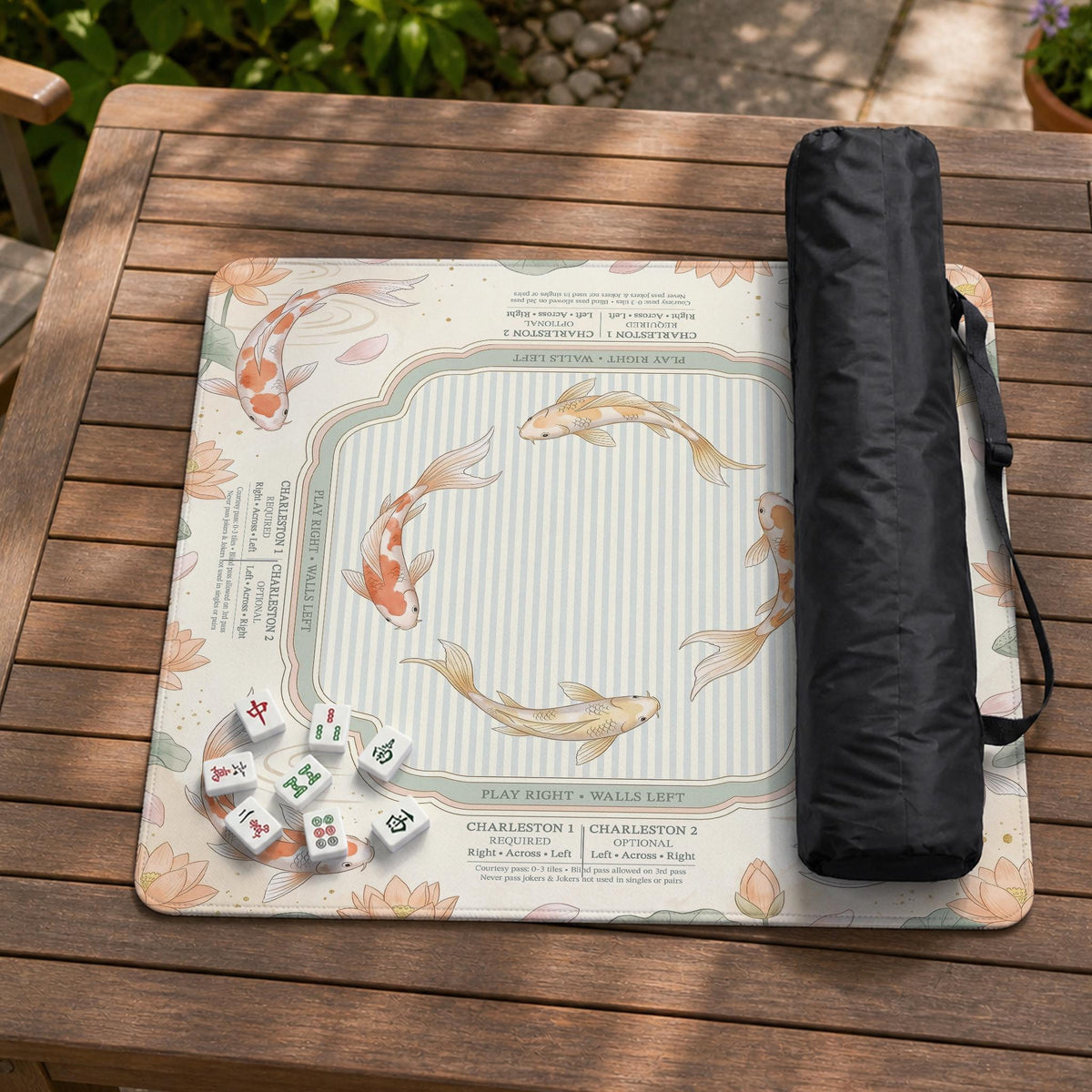 Sage and cream mahjong mat with a koi fish pond pattern, lotus blooms, water ripples, and printed instructions around the border. One version has a scalloped edge.