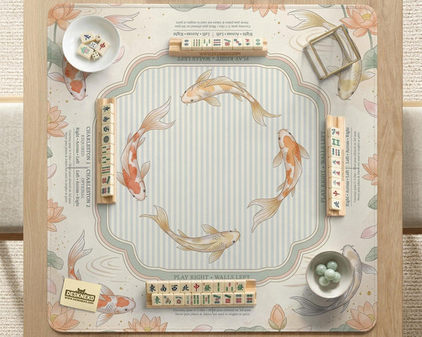 Sage and cream mahjong mat with a koi fish pond pattern, lotus blooms, water ripples, and printed instructions around the border. One version has a scalloped edge.