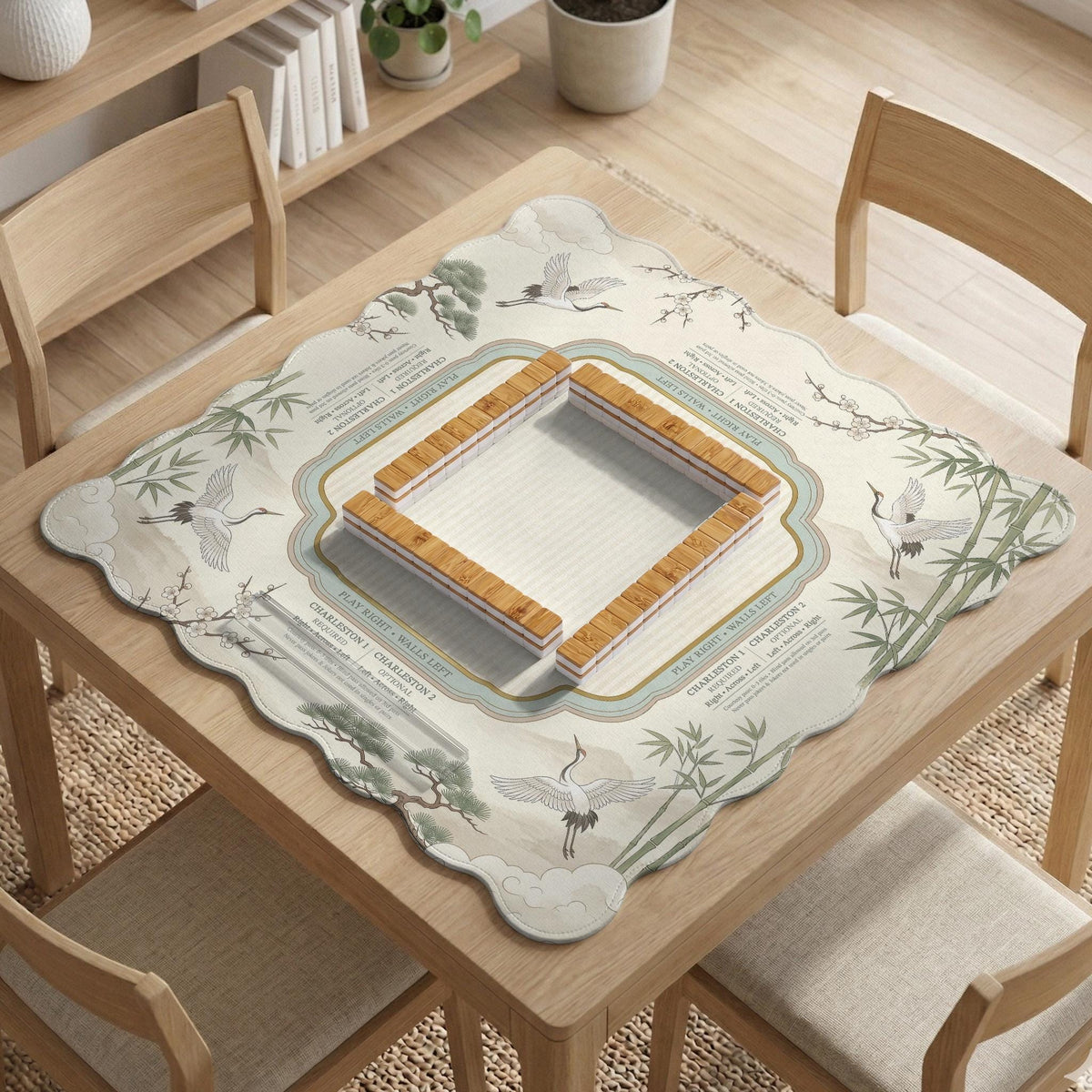 Sage green scalloped mahjong mat with bamboo, crane, and blossom illustration and printed rules around the border.