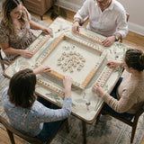 Sage green scalloped mahjong mat with bamboo, crane, and blossom illustration and printed rules around the border.