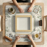 Sage green scalloped mahjong mat with bamboo, crane, and blossom illustration and printed rules around the border.