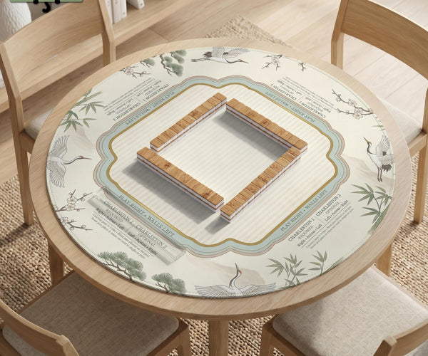 Sage green scalloped mahjong mat with bamboo, crane, and blossom illustration and printed rules around the border.