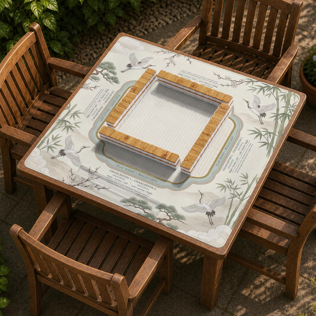 Sage green scalloped mahjong mat with bamboo, crane, and blossom illustration and printed rules around the border.