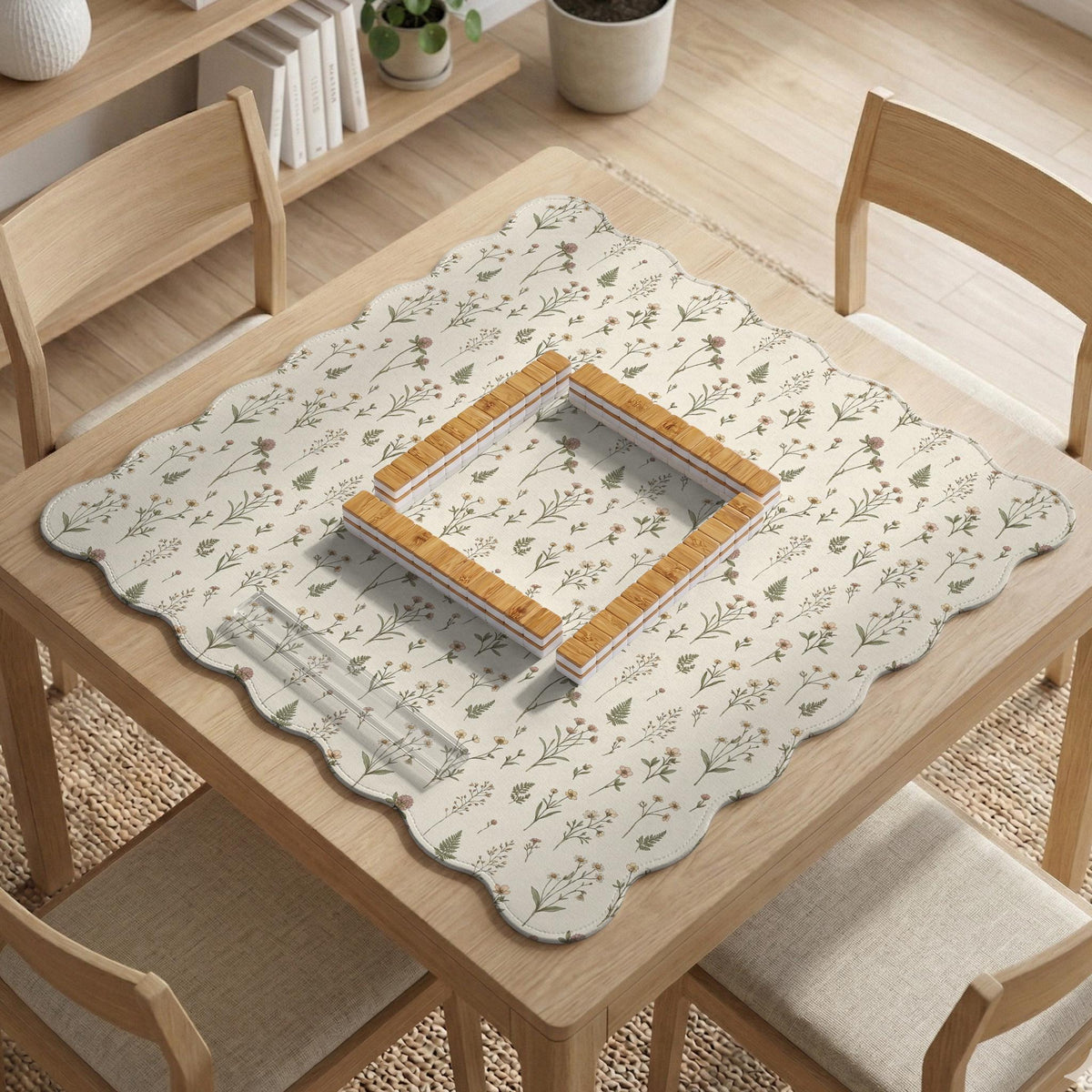 Cream mahjong mat with a floral pattern of small wildflowers and sage leaves, shown with a scalloped edge on a light neutral background.