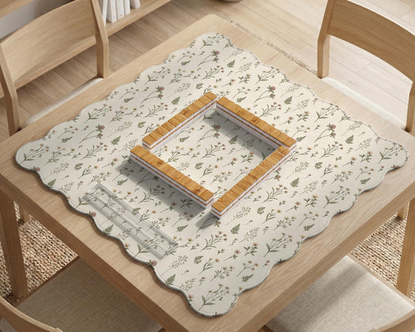 Cream mahjong mat with a floral pattern of small wildflowers and sage leaves, shown with a scalloped edge on a light neutral background.