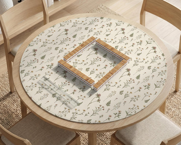 Cream mahjong mat with a floral pattern of small wildflowers and sage leaves, shown with a scalloped edge on a light neutral background.