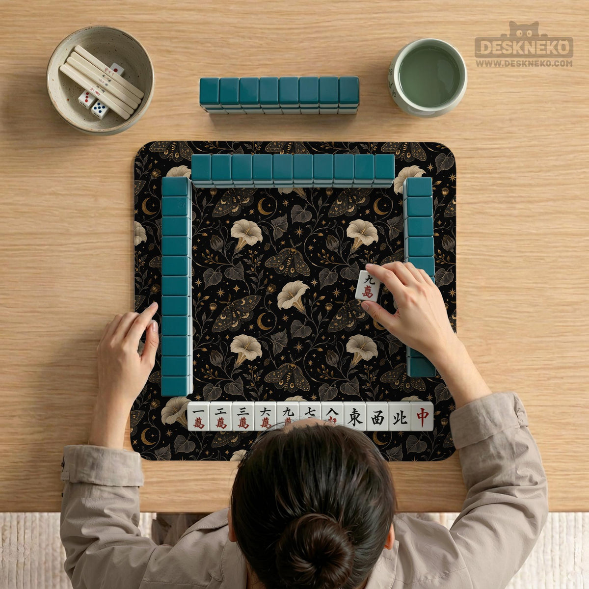 Black square mahjong mat with moths, moonflowers, crescent moons, and scattered stars in a celestial floral pattern.