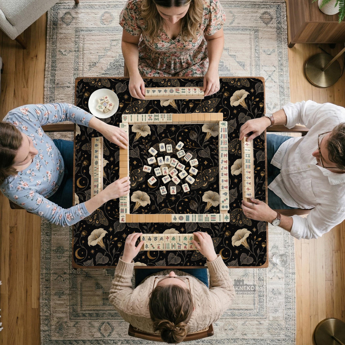 Black square mahjong mat with moths, moonflowers, crescent moons, and scattered stars in a celestial floral pattern.