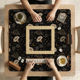 Black square mahjong mat with moths, moonflowers, crescent moons, and scattered stars in a celestial floral pattern.