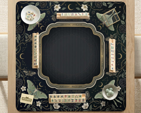 A dark floral mahjong mat with a scalloped edge, moth and flower artwork, and an American Mahjong rules layout on a dark background.