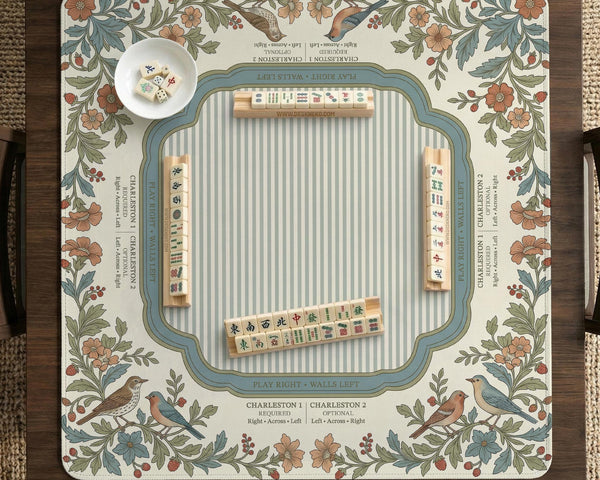 Square mahjong mat with a cream background, blue birds, sage leaves, terracotta flowers, and a decorative botanical border with printed rules text.