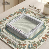 Square mahjong mat with a cream background, blue birds, sage leaves, terracotta flowers, and a decorative botanical border with printed rules text.