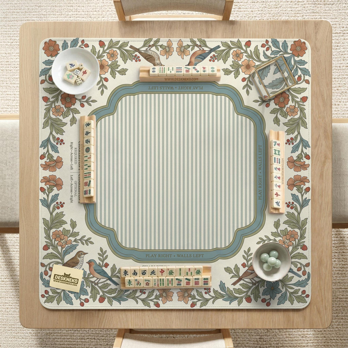 Square mahjong mat with a cream background, blue birds, sage leaves, terracotta flowers, and a decorative botanical border with printed rules text.