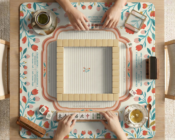 Cream mahjong mat with a coral and teal floral border, rule layout text, Charleston guide notes, and a blank center area for tile play.