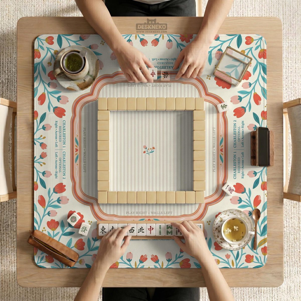 Cream mahjong mat with a coral and teal floral border, rule layout text, Charleston guide notes, and a blank center area for tile play.
