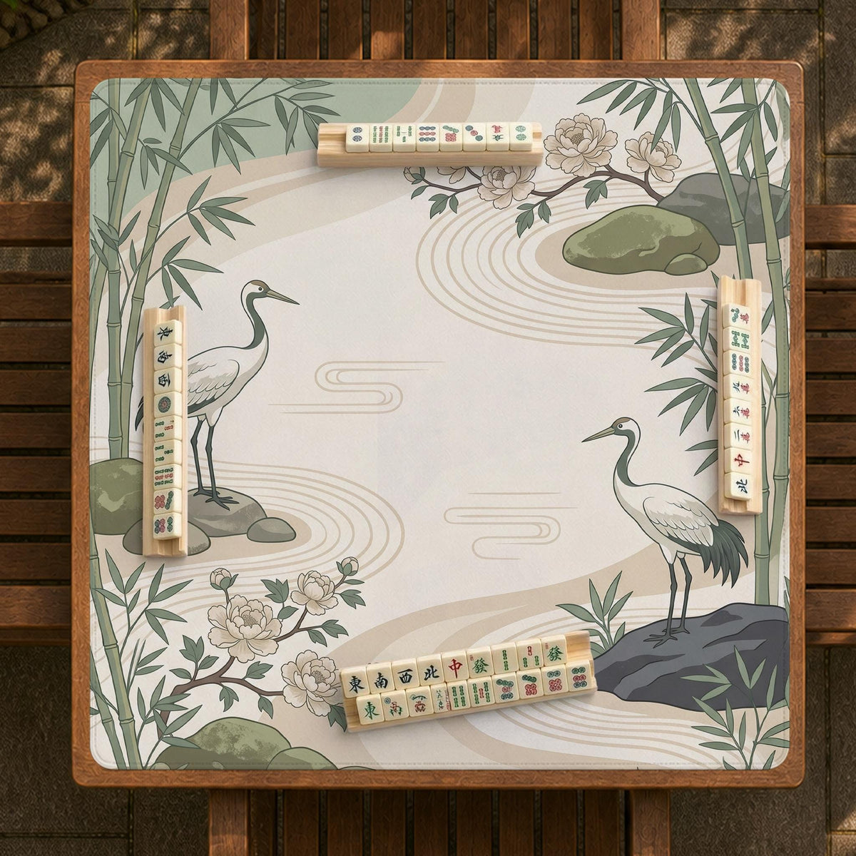 Square mahjong mat with a cream background, sage green cranes, bamboo leaves, peony branches, stones, and thin linework.