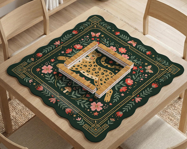 Dark green square mahjong mat with a golden spotted leopard in the center, surrounded by flowers, leafy stems, butterflies, and small star accents.