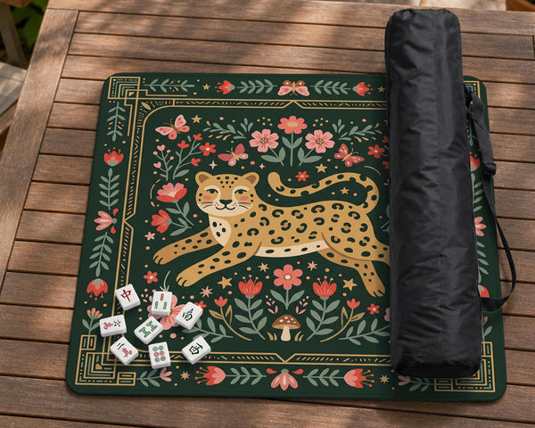 Dark green square mahjong mat with a golden spotted leopard in the center, surrounded by flowers, leafy stems, butterflies, and small star accents.