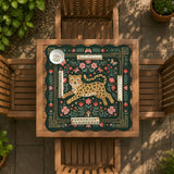Dark green square mahjong mat with a golden spotted leopard in the center, surrounded by flowers, leafy stems, butterflies, and small star accents.