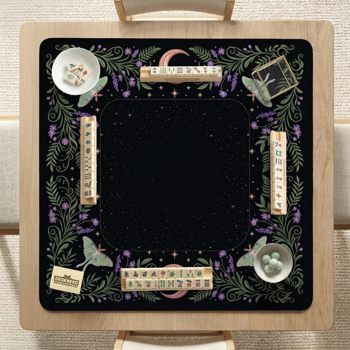 Black mahjong table mat with luna moths, purple flowers, soft green leaves, copper moons, and small star details.