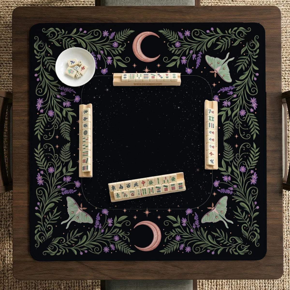 Black mahjong table mat with luna moths, purple flowers, soft green leaves, copper moons, and small star details.
